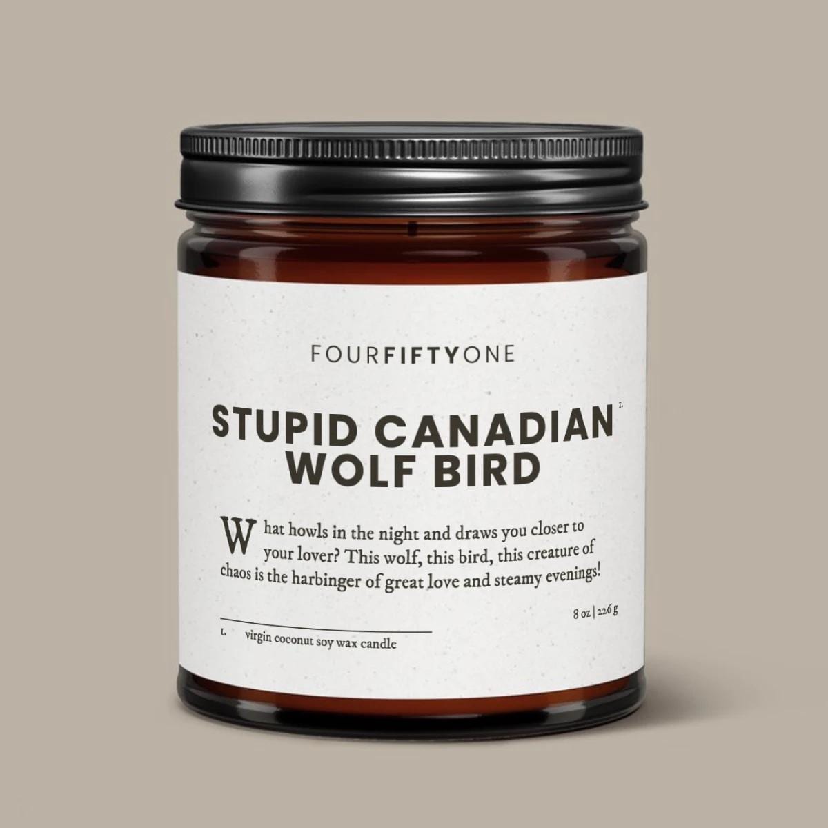 Stupid Canadian Wolf Bird Heated Rivalry soy candle in an amber glass jar with a black lid, cream label with FOURFIFTYONE branding.